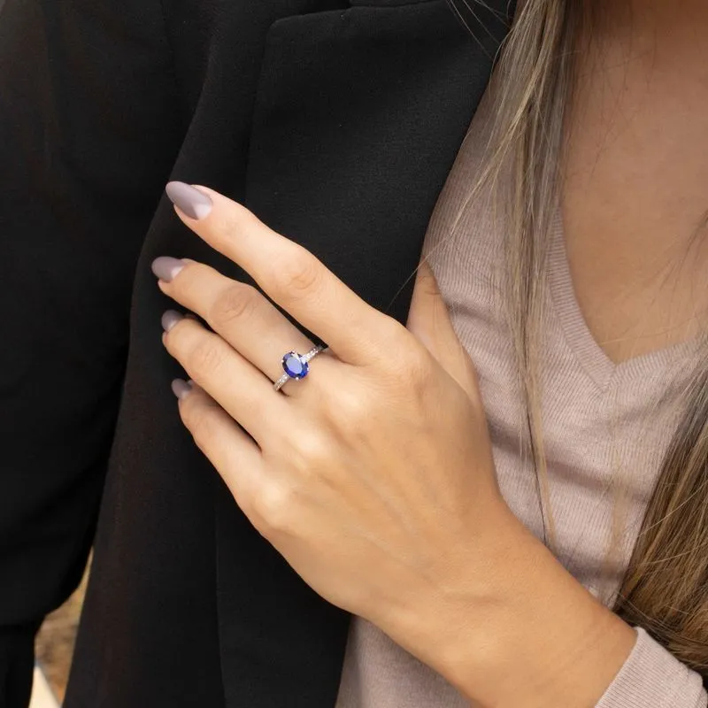 White gold ring with white zircons and a prominent oval blue stone